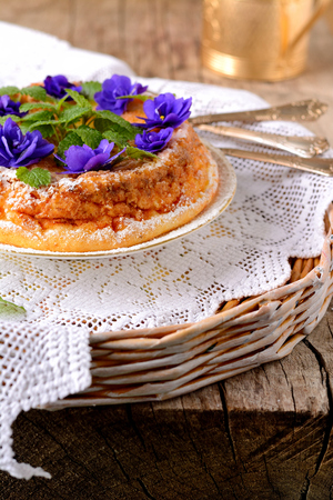 Casserole of cottage cheese with violets on wooden tableの写真素材