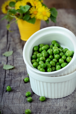 Green peas on wooden tableの写真素材