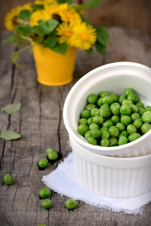 Green peas on wooden tableの写真素材