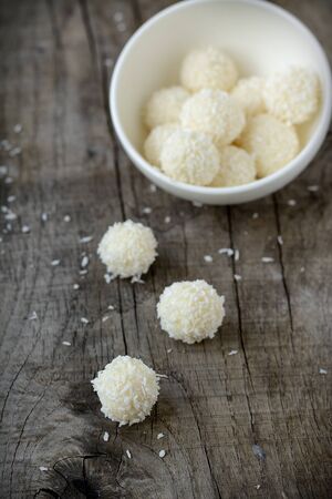 Homemade candies with coconut on wooden tableの写真素材
