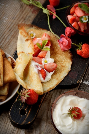 Colorful view of a tasty pancake with ice cream, strawberries in rustic styleの写真素材