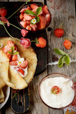 Colorful view of a tasty pancake with ice cream, strawberries in rustic styleの写真素材