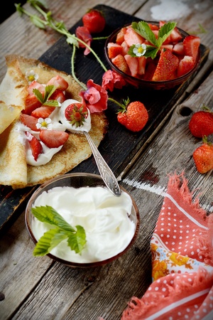 Colorful view of a tasty pancake with ice cream, strawberries in rustic styleの写真素材