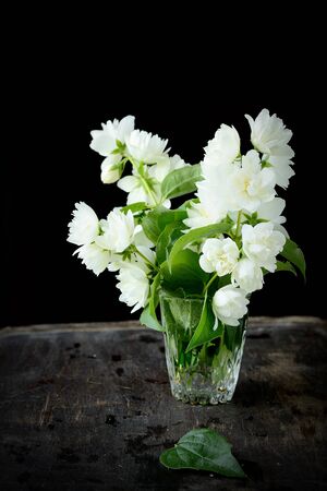 Fragrant jasmine bouquet in a vase on the tableの写真素材