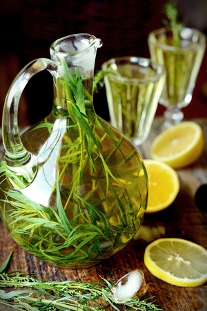 Green estragon lemonade pitcher with two glasses on a wooden table in the sun の写真素材