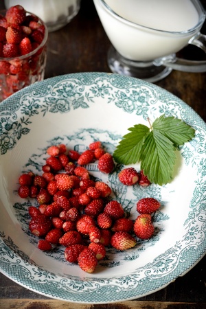 Wild strawberry with milk in rusticの写真素材