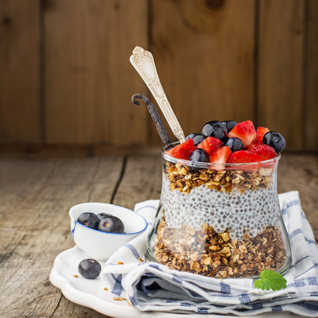 Strawberry, blueberries, oatmeal and chia seeds pudding in a jar for breakfastの写真素材