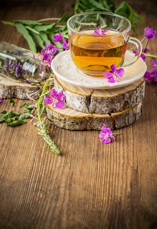blooming Sally in a transparent cup and fresh flowers in the vase life on a wooden background. selective Focusの写真素材