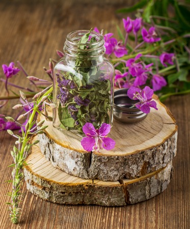 blooming Sally in a transparent cup and fresh flowers in the vase life on a wooden background. selective Focusの写真素材
