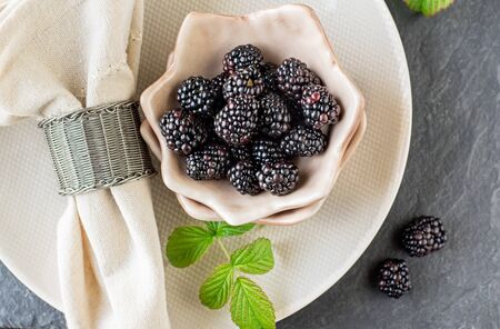 Fresh blackberries for breakfast in ceramic cups portioned. Selective focus.の写真素材