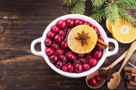 Cranberry sauce in ceramic saucepan on dark background. Selective focus