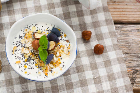 Healthy breakfast. A cup of yogurt with granola, seeds, nuts and berries, pollen portions served with a cup of coffee for a family breakfast. The concept of organic nutritionの写真素材