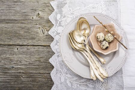 Culinary background. Serving for dinner with quail eggs, dishes silverware, fresh bread on a vintage...