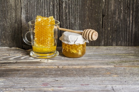 Natural organic lime honey in honeycombs with a private apiary on a textured wooden dark background in a horizontal version.の写真素材