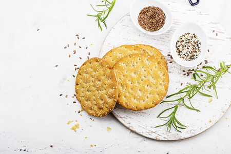 Thin crispy grain breads for breakfast with flax seeds and sesame seeds on a light background. Top Viewの写真素材