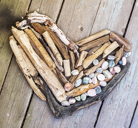 Various figures and letters from driftwood and colored stones on a simple wooden gray background. Top view.の写真素材