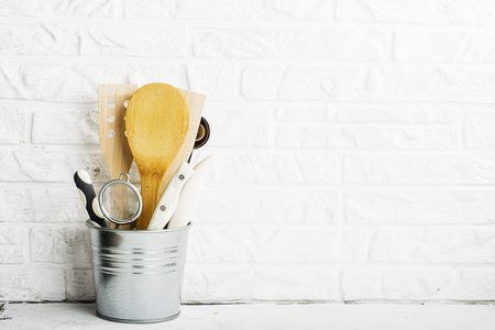 Kitchen tools, olive cutting board on a kitchen shelf against a white brick wall. selective focus.の写真素材
