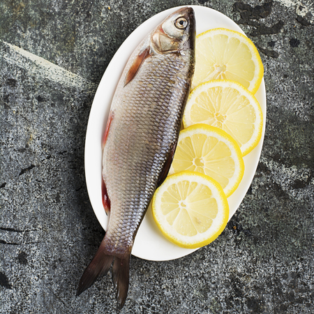 The raw ingredients are fish and vegetables for cooking. River fish of carp breeds with onion,...