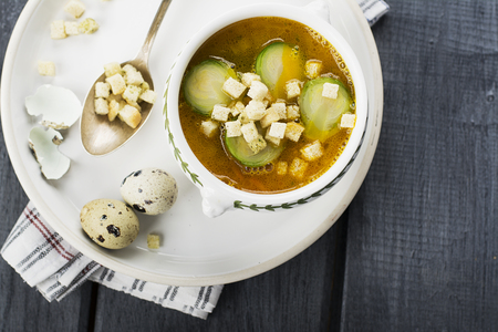 Homemade soup with brussels sprouts and croutons in white bowl decorated with a sprig of thyme. selective Focusの写真素材