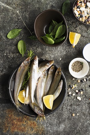 Fresh sea cold-water small fish such as smelt, sardine, anchovies on a simple background with fresh...