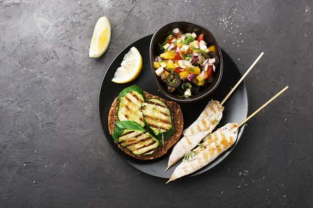 Toast with zucchini grill and salad of olives, cucumbers, tomato, sweet red onion, yellow chili pepper with grilled chicken breast. Top View.の写真素材