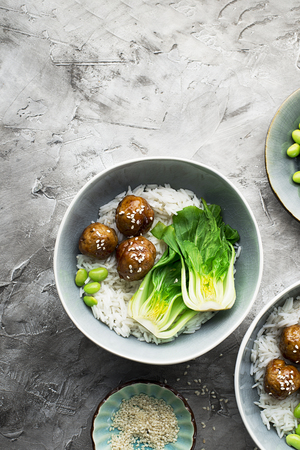 Healthy home cooking. Meat balls teriyaki, rice, cabbage bok choy bowl with sesame seeds in a ceramic dish. Top View.の写真素材