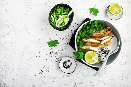 Rice chicken breast bowl with spring green onions and herbs.の写真素材