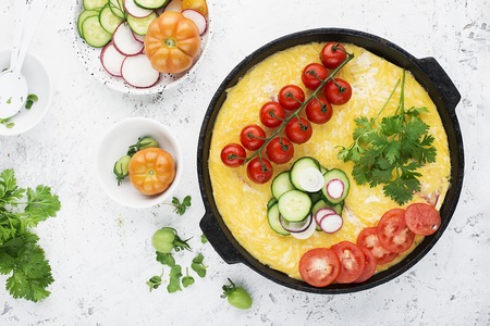 Farmer market vegetables garden one pot casserole: tomatoes, cauliflower, zucchini, onion, cheese, organic eggs in a cast-iron frying pan. Top view. Copy spaceの写真素材