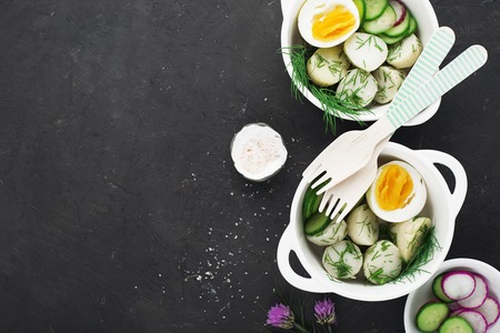 Potato salad with dill and boiled egg on a dark background. Top view.の写真素材