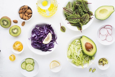 Clean food. Fresh raw vegetables and lettuce leaves to prepare a healthy snack meal salad. Top view. On a light background.の写真素材