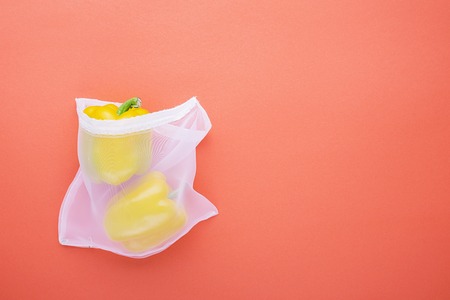 Zero waste shopping vegetables in thin fabric natural bags on a bright colored coralの写真素材