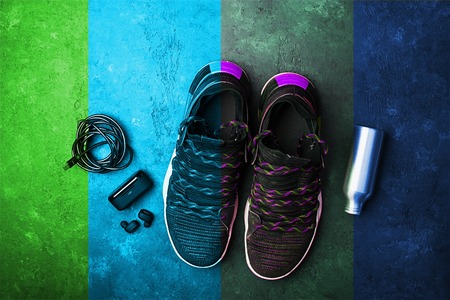 Sneakers, headphones, water bottle. The concept of the sport of life in motion.