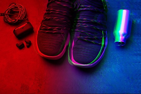 Retro wave neon. Sneakers, air headphones, water bottle in bright neon color tinted.