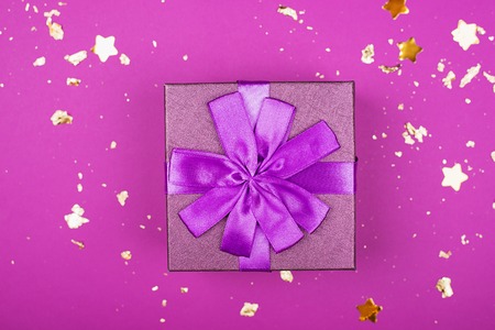 Festive golden box on proton purple trend bright  with gold sparkles.