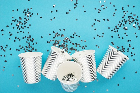 Universal festive blue background with silver confetti and glitter with paper cups. The main trend concept is no plastic on a clean planet. Horizontal, space for textの写真素材