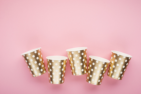 Universal trendy festive background pink gold with confetti, paper fashion cups on a delicate pink background. Concept for any fun bright project. Horizontal, copy spaceの写真素材