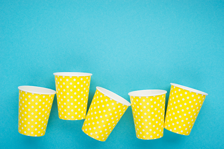 Paper yellow cups on a blue background. The main concept of plastic free on a clean planet. Horizontal, copy space,の写真素材