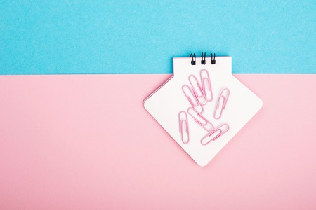 Empty Notebook or notepad on pink and blue background. Creative minimalism chancery concept. Top...