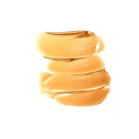 Brush strokes golden paint texture cosmetics isolated on whiteの写真素材