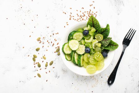 Healthy green food. Juicy celery, cucumbers, grapes, blueberries, lettuce, sorrel detox salad. Food without meat Top viewの写真素材