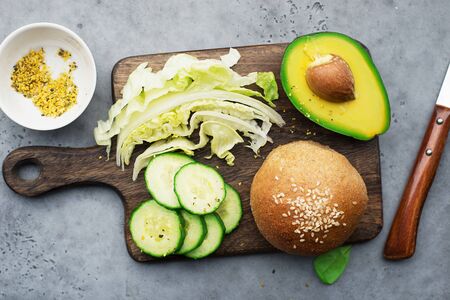 Healthy ingredients clean food. Avocado, whole grain bread, greens, lettuce, vegetables for a comfortable diet. Top view.の写真素材