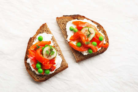 Grain bread slices for sandwiches with curd cheese, baked capsicum, green fresh peas and mint on a light background. Top view,の写真素材