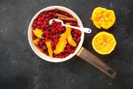 Cranberry orange sauce. Traditional home cooking christmas, thanksgiving recipe for cozy classic food. Cooking ingredients cinnamon, brown sugar, orange juice, red berries. Top view.の写真素材