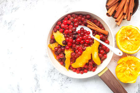 Cranberry orange sauce. Traditional home cooking christmas, thanksgiving recipe for cozy classic food. Cooking ingredients cinnamon, brown sugar, orange juice, red berries. Top view.の写真素材