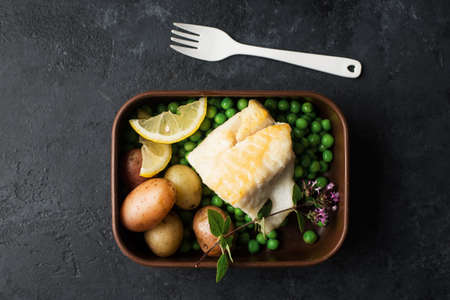 Fish fillet cod lunch box. Boiled new potatoes, green peas, boiled white cod fish for lunch in the lunch box with you. Takeawayの写真素材