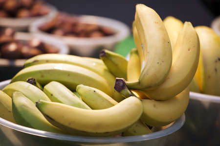 Group of fresh yellow bananas in a bowl on marketの写真素材