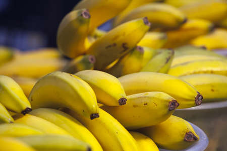 Group of fresh yellow bananas in a bowl on marketの写真素材
