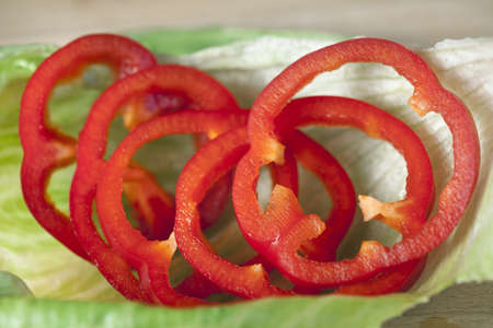Group of fresh red peppers on a lettuce on wooden deskの写真素材