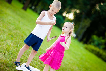 Little boy and girl  with ladybird in park during beautiful summer eveningの写真素材