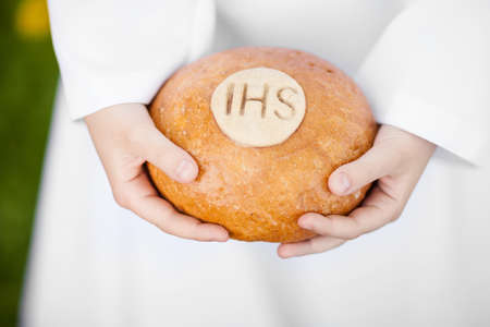 First Holy Communion concept - close up on bread in child's handsの写真素材